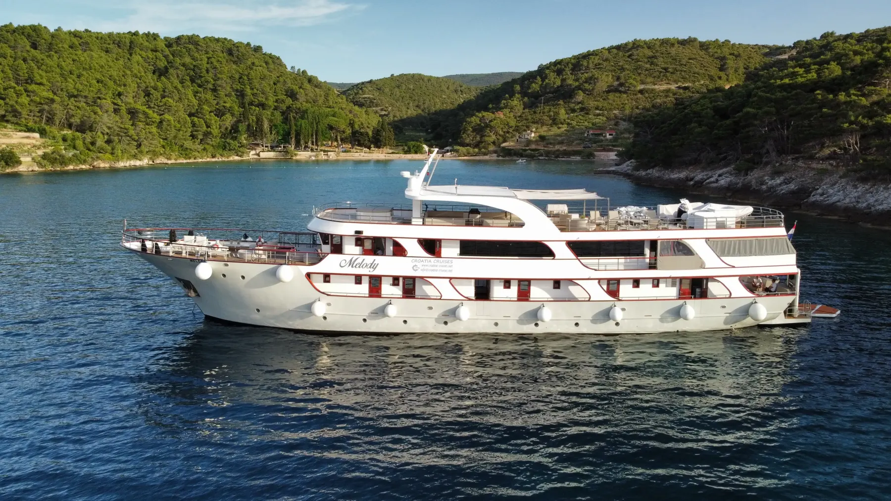 MS Melody anchored in a green Adriatic bay at golden hour